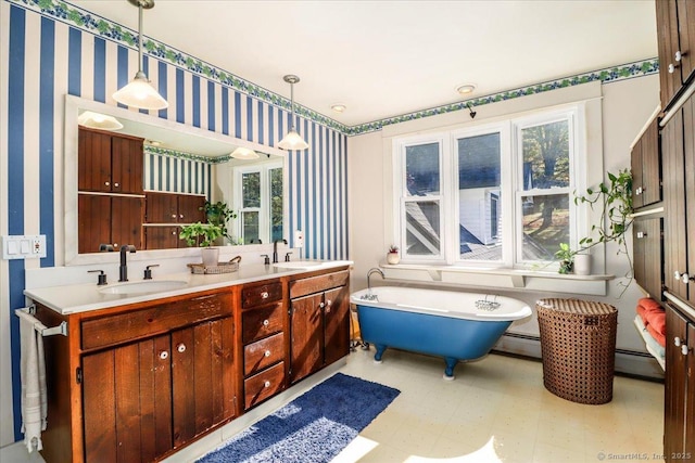 bathroom with wallpapered walls, a sink, tile patterned floors, and a freestanding bath