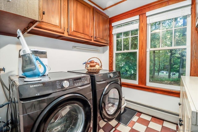 laundry room featuring washing machine and clothes dryer, cabinet space, tile patterned floors, and baseboard heating