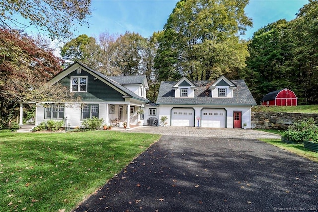 view of front of house featuring an outdoor structure, aphalt driveway, and a front lawn