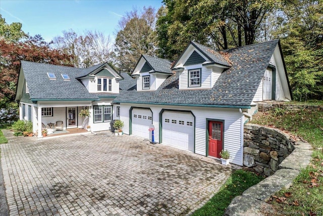 view of front of property featuring decorative driveway and a shingled roof