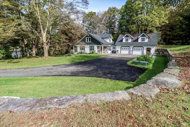view of front of property featuring an attached garage, aphalt driveway, and a front yard