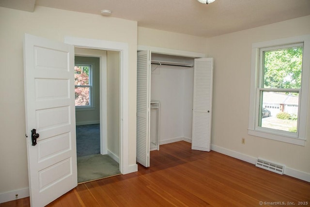 26 Seminary Rd, Simsbury, CT 06070 - unfurnished bedroom with multiple windows, wood finished floors, and a closet