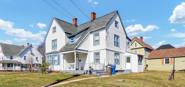 view of front of property with a chimney, a porch, a front yard, and a residential view
