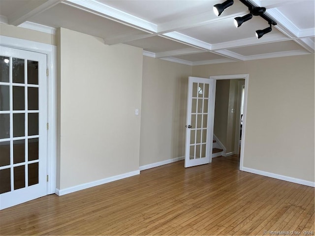 empty room with light wood-style flooring, baseboards, beam ceiling, french doors, and coffered ceiling