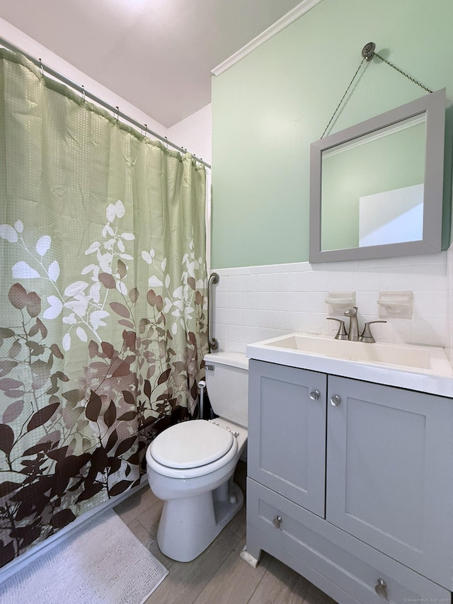 2811 Fairfield Ave Unit 1, Bridgeport, CT 06605 - full bathroom with tile walls, toilet, vanity, a wainscoted wall, and wood finished floors