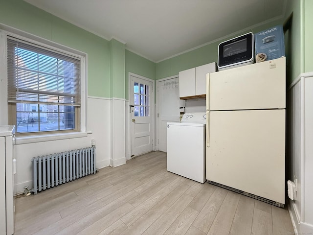 2811 Fairfield Ave Unit 1, Bridgeport, CT 06605 - clothes washing area with radiator heating unit, washer / clothes dryer, light wood finished floors, and crown molding