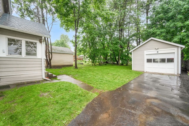 134 Saint Charles St, West Hartford, CT 06119 - view of green lawn with an outdoor structure, asphalt driveway, and a garage