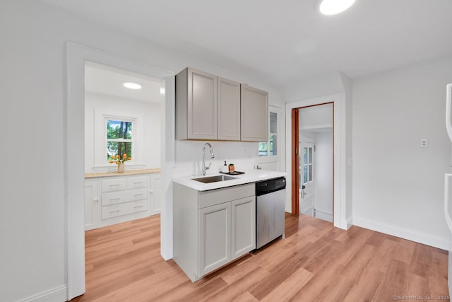 134 Saint Charles St, West Hartford, CT 06119 - kitchen with stainless steel dishwasher, a sink, light wood-style floors, and gray cabinets