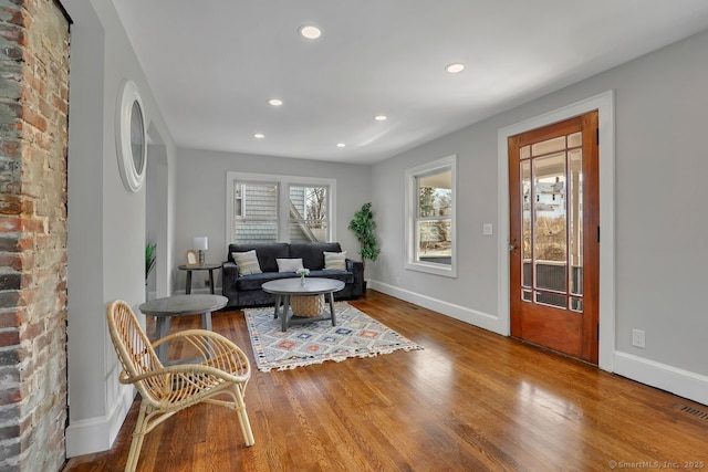living area featuring baseboards, wood finished floors, and recessed lighting