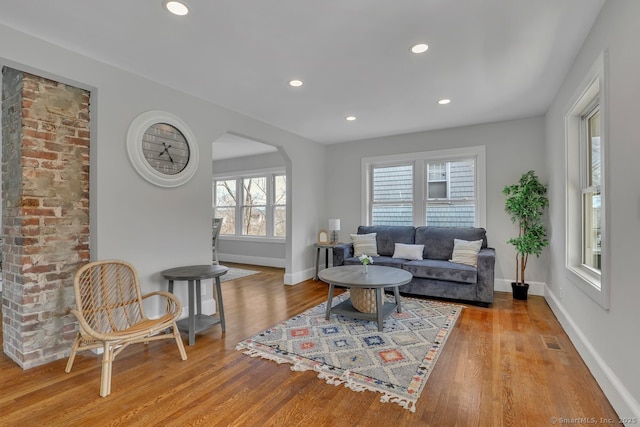 living area featuring baseboards, visible vents, and wood finished floors