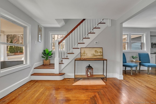 stairway with baseboards and parquet flooring