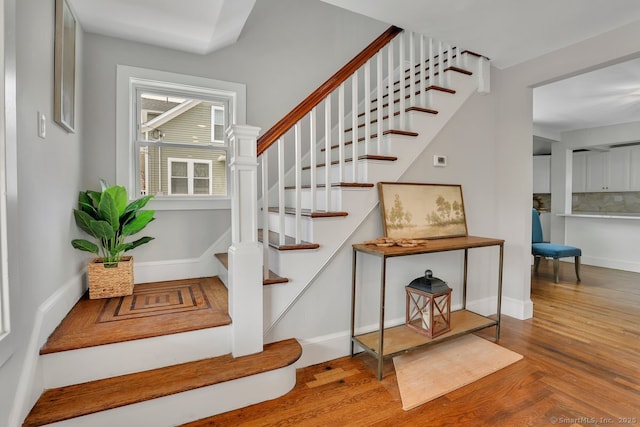 stairs featuring baseboards and wood finished floors
