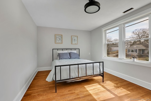 bedroom with baseboards and light wood finished floors