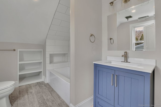 bathroom featuring vanity, vaulted ceiling, toilet, baseboards, and wood tiled floor