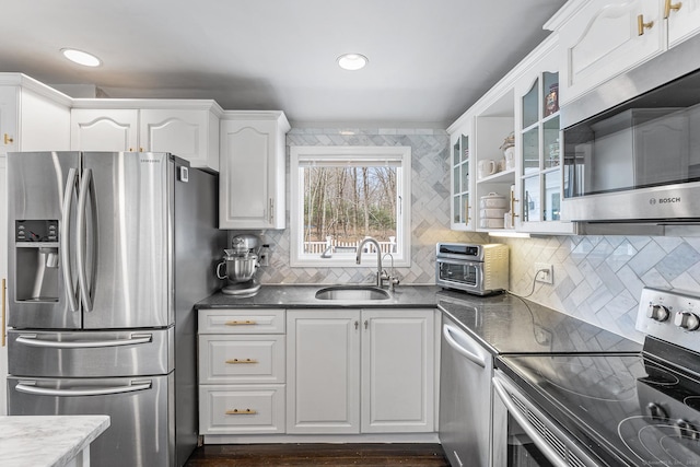 21 White Birch Rd, Redding, CT 06896 - kitchen with a sink, white cabinetry, backsplash, glass insert cabinets, and appliances with stainless steel finishes