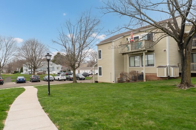 view of yard featuring central AC, a residential view, and a balcony
