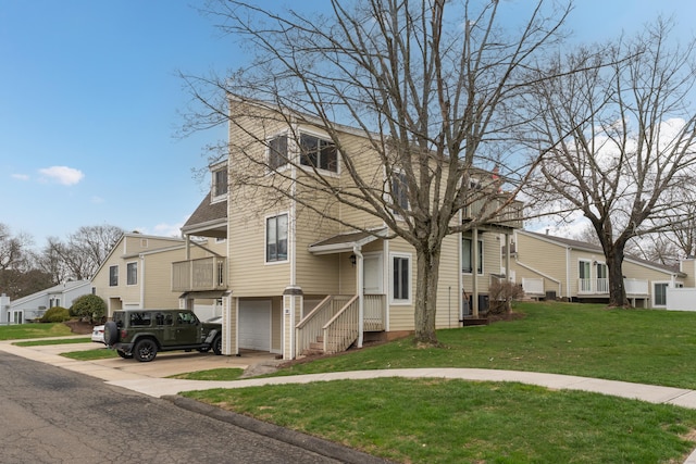 view of front of home featuring an attached garage, concrete driveway, a residential view, and a front lawn