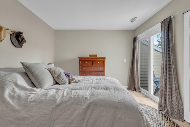 bedroom featuring baseboards, light wood-style floors, access to exterior, and visible vents