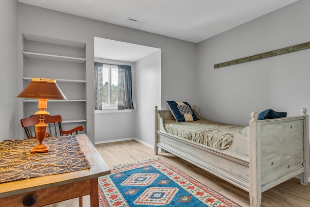 bedroom featuring wood finished floors, baseboards, and visible vents