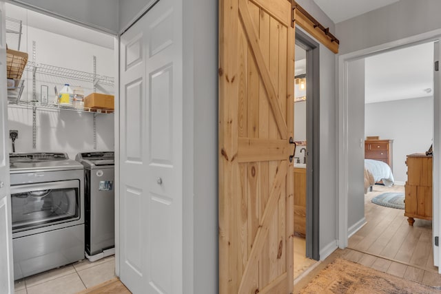 kitchen featuring a barn door, independent washer and dryer, and baseboards