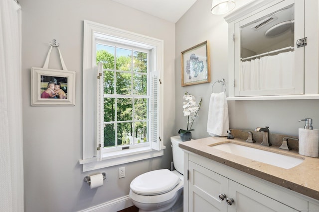 bathroom with toilet, visible vents, and vanity