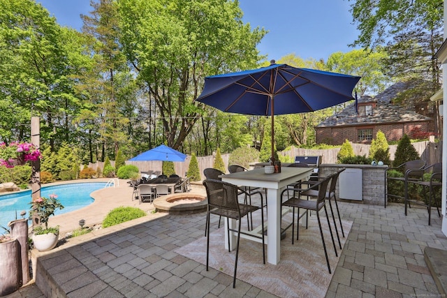 view of patio / terrace with outdoor dining area, a fenced backyard, and a fenced in pool