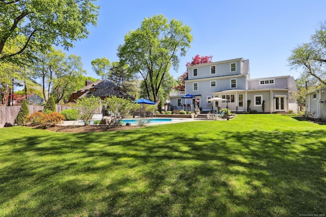 back of house featuring a fenced in pool, a patio area, fence, and a yard