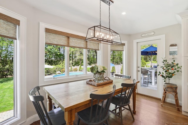 dining room featuring baseboards, wood finished floors, and a notable chandelier