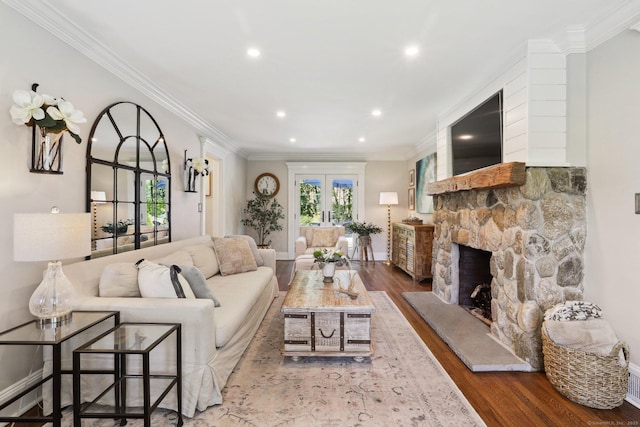 living room with a stone fireplace, wood finished floors, baseboards, ornamental molding, and recessed lighting