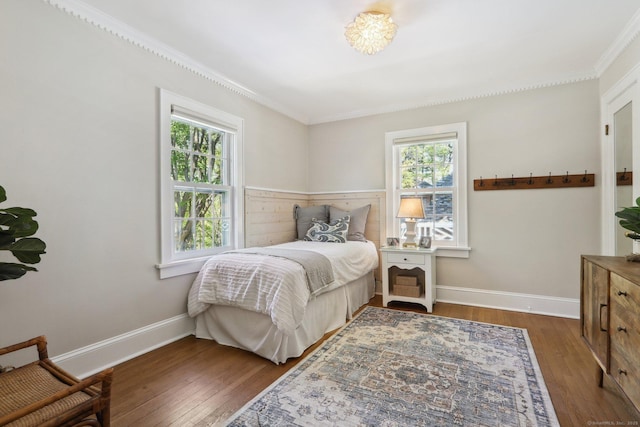 bedroom featuring multiple windows, ornamental molding, and hardwood / wood-style floors