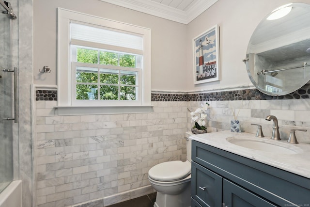 bathroom featuring crown molding, wainscoting, vanity, toilet, and a shower with door