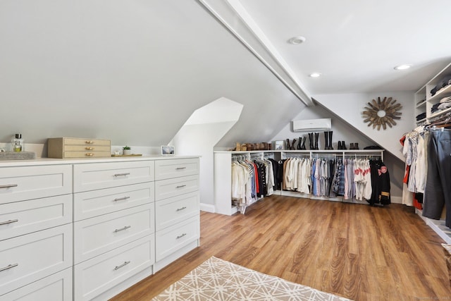 spacious closet featuring light wood finished floors and lofted ceiling