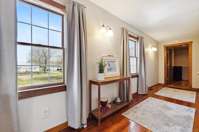 corridor featuring dark wood-type flooring, baseboards, and visible vents