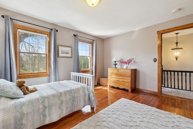 bedroom featuring baseboards and hardwood / wood-style flooring