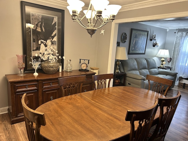 dining room featuring wood finished floors, an inviting chandelier, baseboards, and ornamental molding