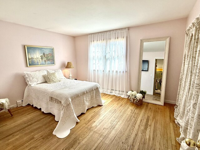 bedroom featuring baseboards and wood finished floors