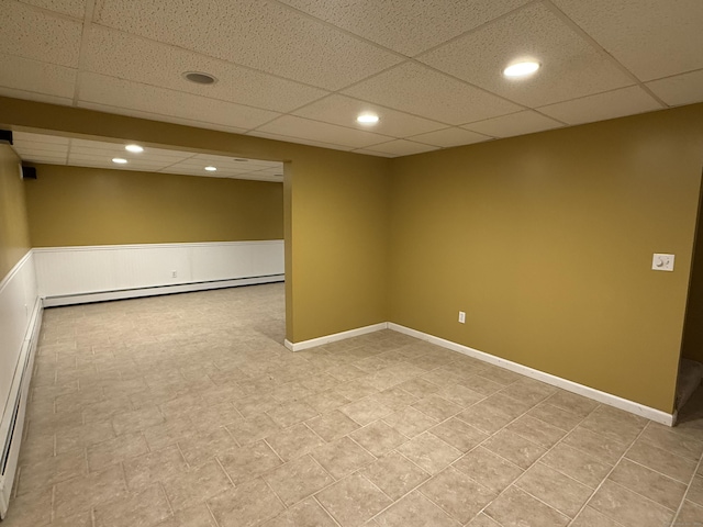 empty room featuring a paneled ceiling, recessed lighting, baseboards, and baseboard heating