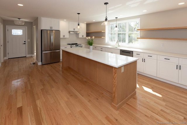 58 Killingworth Tpke, Clinton, CT 06413 - kitchen with open shelves, a center island, stainless steel appliances, under cabinet range hood, and a sink