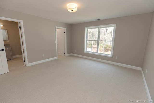 58 Killingworth Tpke, Clinton, CT 06413 - unfurnished bedroom featuring connected bathroom, baseboards, light colored carpet, and visible vents