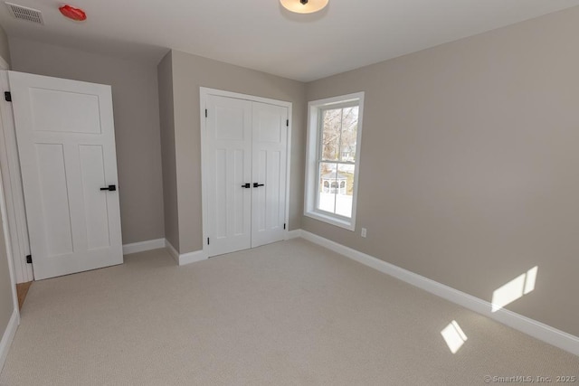 58 Killingworth Tpke, Clinton, CT 06413 - unfurnished bedroom with baseboards, visible vents, a closet, and light carpet