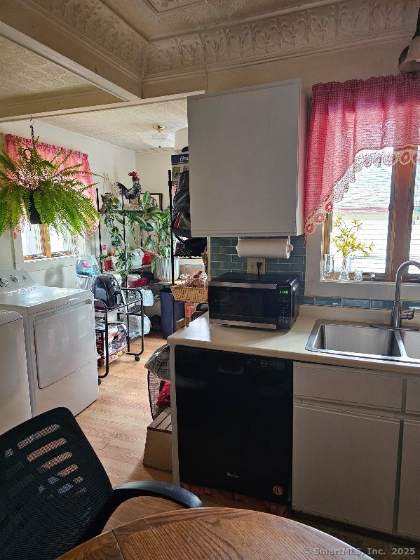 125 Mckinley Ave, Norwich, CT 06360 - kitchen with black appliances, washing machine and clothes dryer, a sink, and light countertops