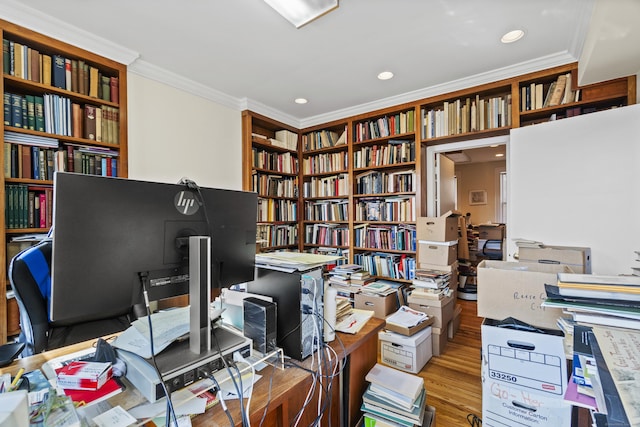 office with wood finished floors, recessed lighting, ornamental molding, and wall of books