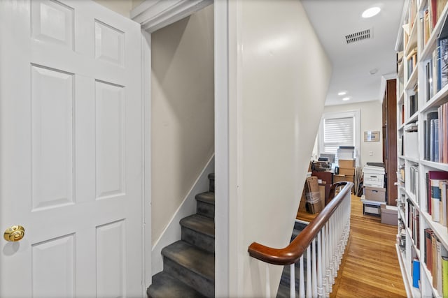 stairs featuring recessed lighting, wood finished floors, and visible vents