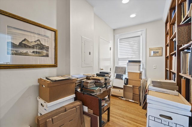 home office with light wood-type flooring, electric panel, and recessed lighting