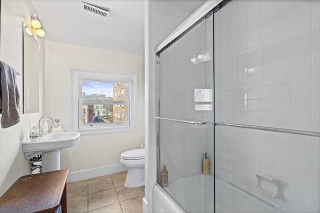 bathroom featuring baseboards, visible vents, bath / shower combo with glass door, and toilet