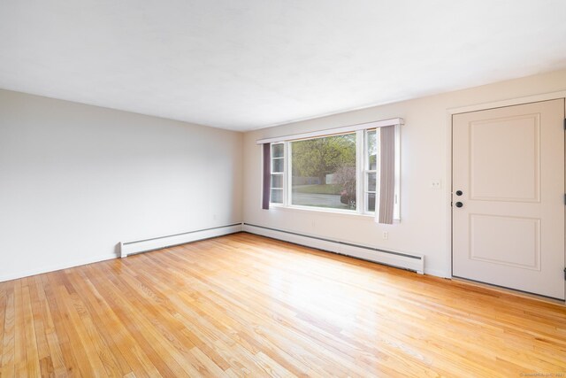 unfurnished living room featuring wood finished floors and a baseboard radiator