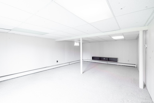 finished basement with a baseboard heating unit and a paneled ceiling