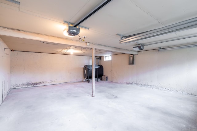 garage with heating fuel, electric panel, and a garage door opener
