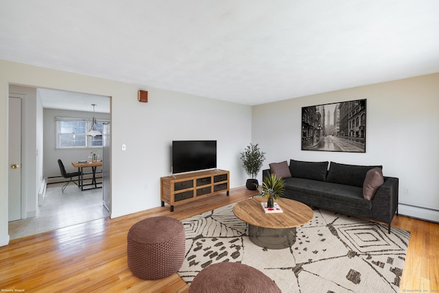 living room with a baseboard radiator, light wood-style flooring, and a baseboard heating unit