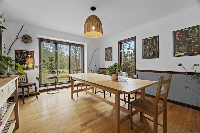 dining area featuring baseboards and light wood finished floors